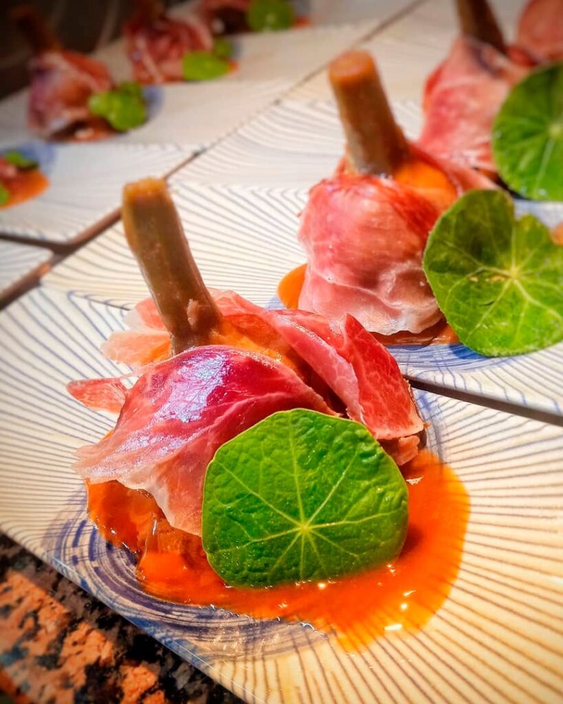 Tierna-alcachofa-cocinada-a-baja-temperatura,-envuelta-en-jamón-ibérico-y-salsa-de-pimiento-de-la-vera-min
